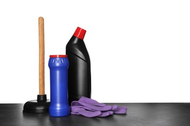 Composition with different toilet cleaning tools on black table against white background. Space for text