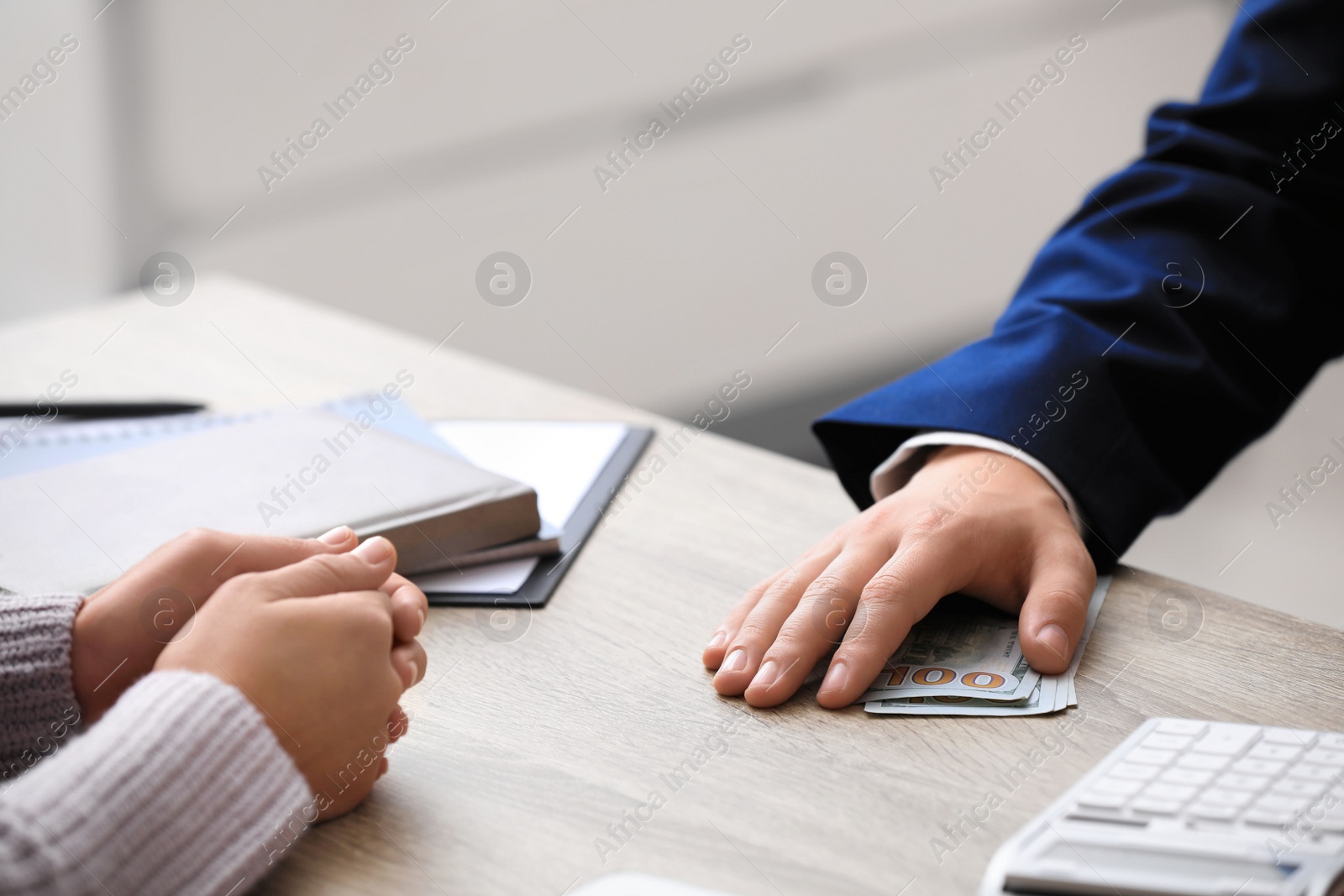 Photo of Man taking bribe money at table indoors, closeup