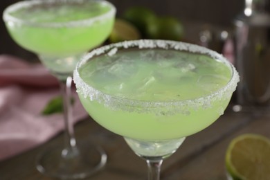 Photo of Delicious Margarita cocktail in glasses on table, closeup