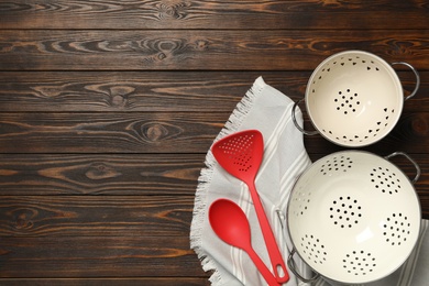 Photo of Set of modern cooking utensils on brown wooden table, flat lay. Space for text