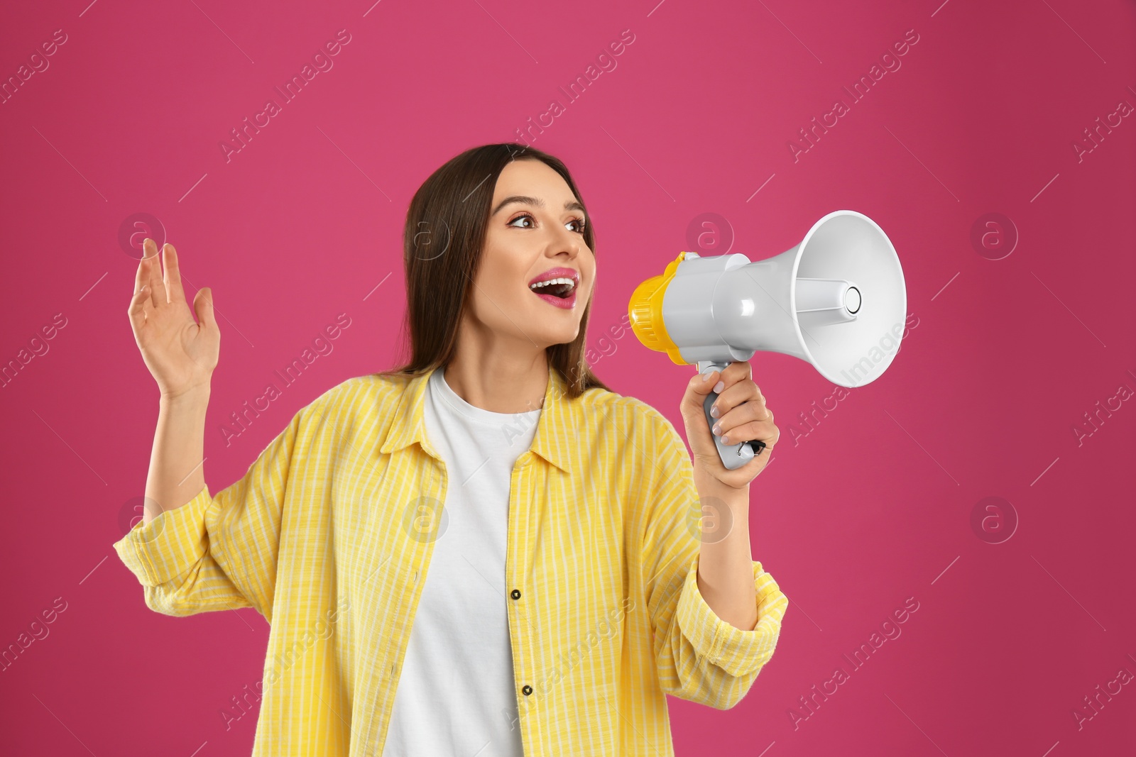 Photo of Young woman with megaphone on pink background