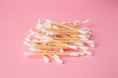 Photo of Heap of clean cotton buds on pink background