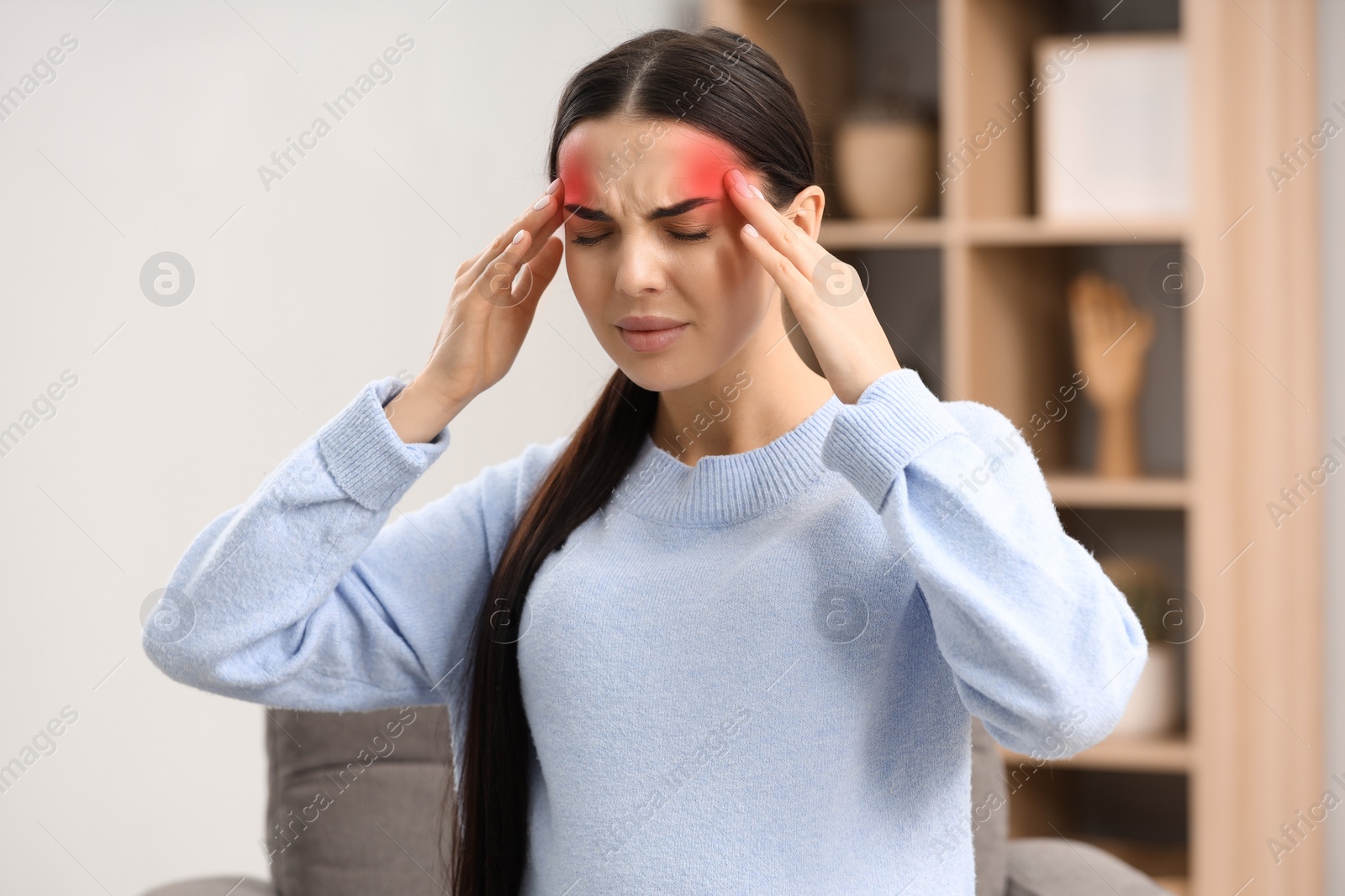 Image of Young woman suffering from headache at home