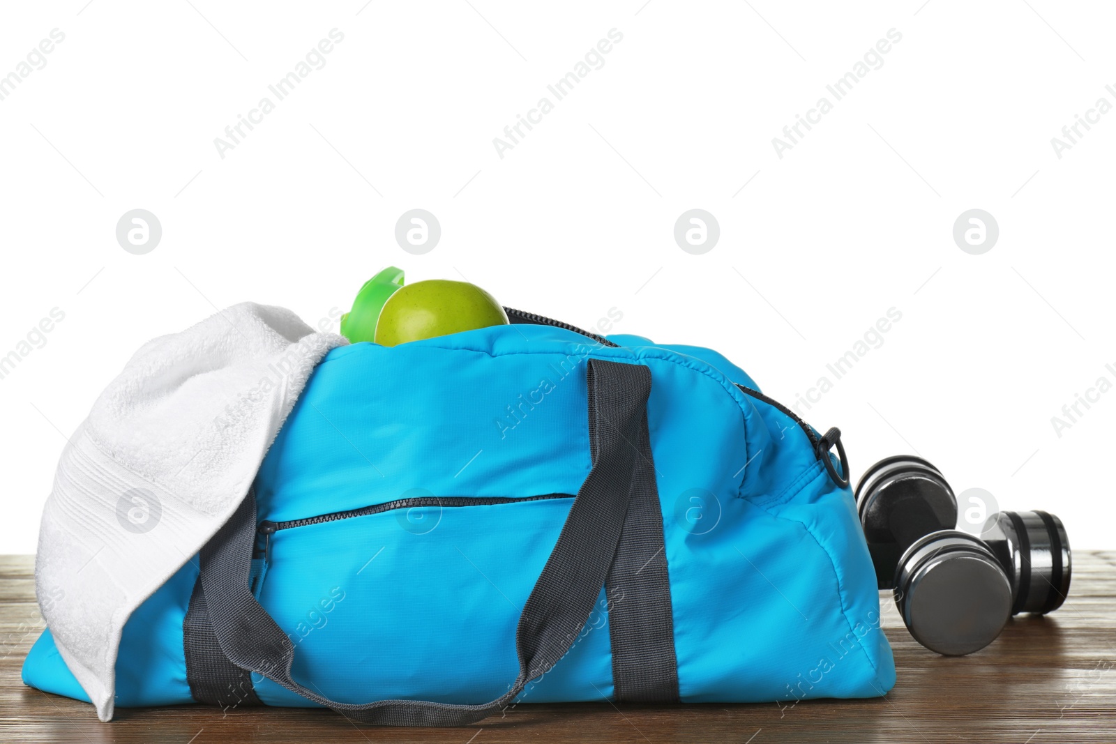 Photo of Sports bag and gym equipment on table against white background