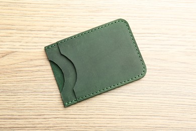 Leather business card holder on wooden table, top view