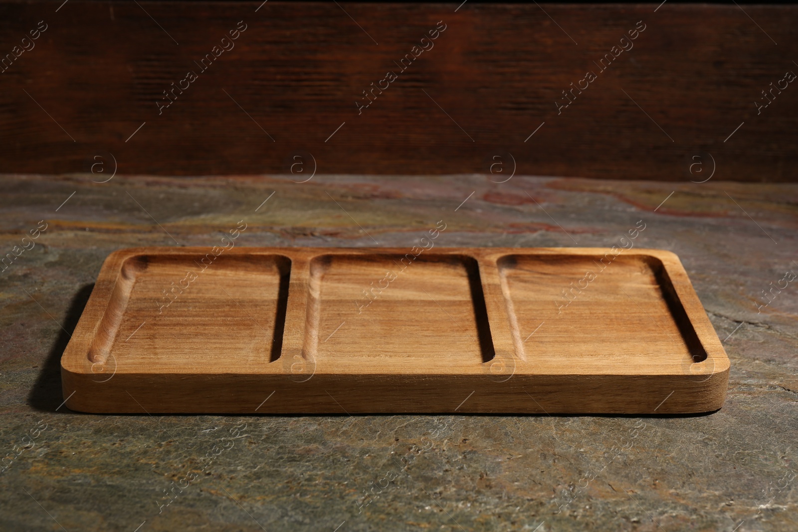 Photo of One wooden serving board on textured table