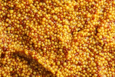 Whole grain mustard as background, top view