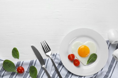 Photo of Romantic breakfast with heart shaped fried egg served on white wooden table, flat lay. Space for text