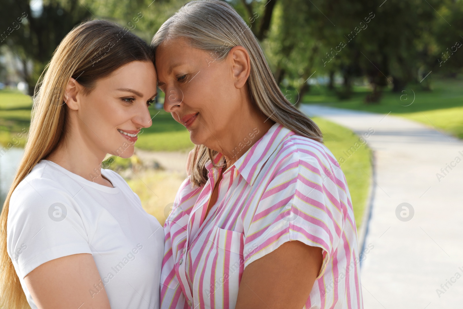 Photo of Family portrait of happy mother and daughter in park. Space for text