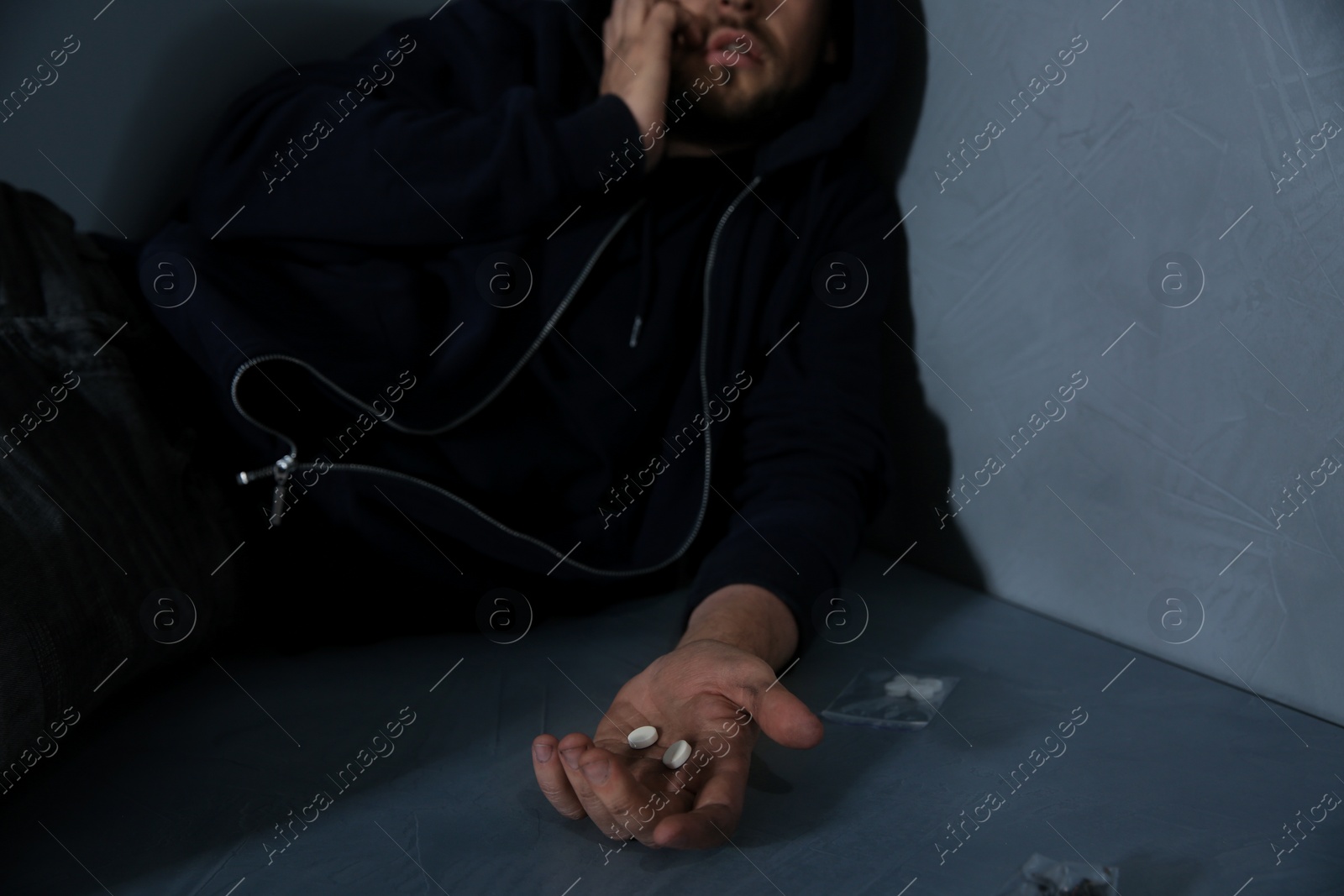 Photo of Young addicted man holding drugs, closeup view