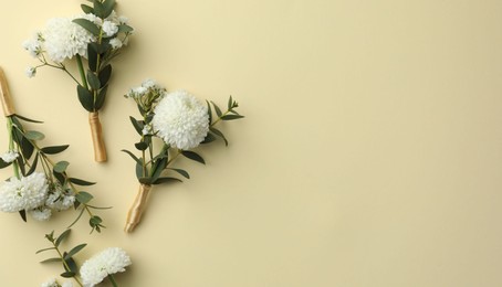 Photo of Many stylish boutonnieres on beige background, flat lay. Space for text