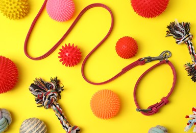 Flat lay composition with dog leash and toys on yellow background