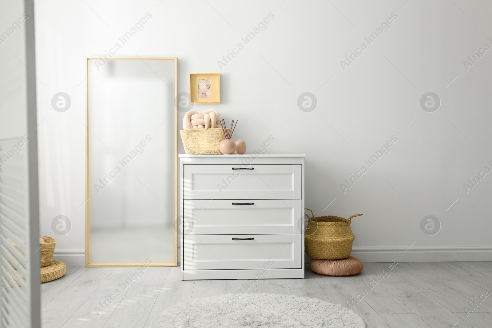 Photo of Modern room interior with white chest of drawers