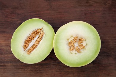 Photo of Cut tasty ripe melon on wooden table, flat lay