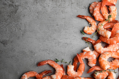 Tasty boiled shrimps with thyme on grey table, flat lay. Space for text