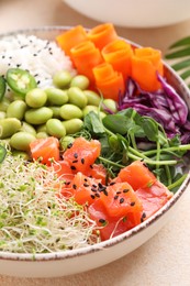 Photo of Delicious poke bowl with quail eggs, fish and edamame beans on light table, closeup