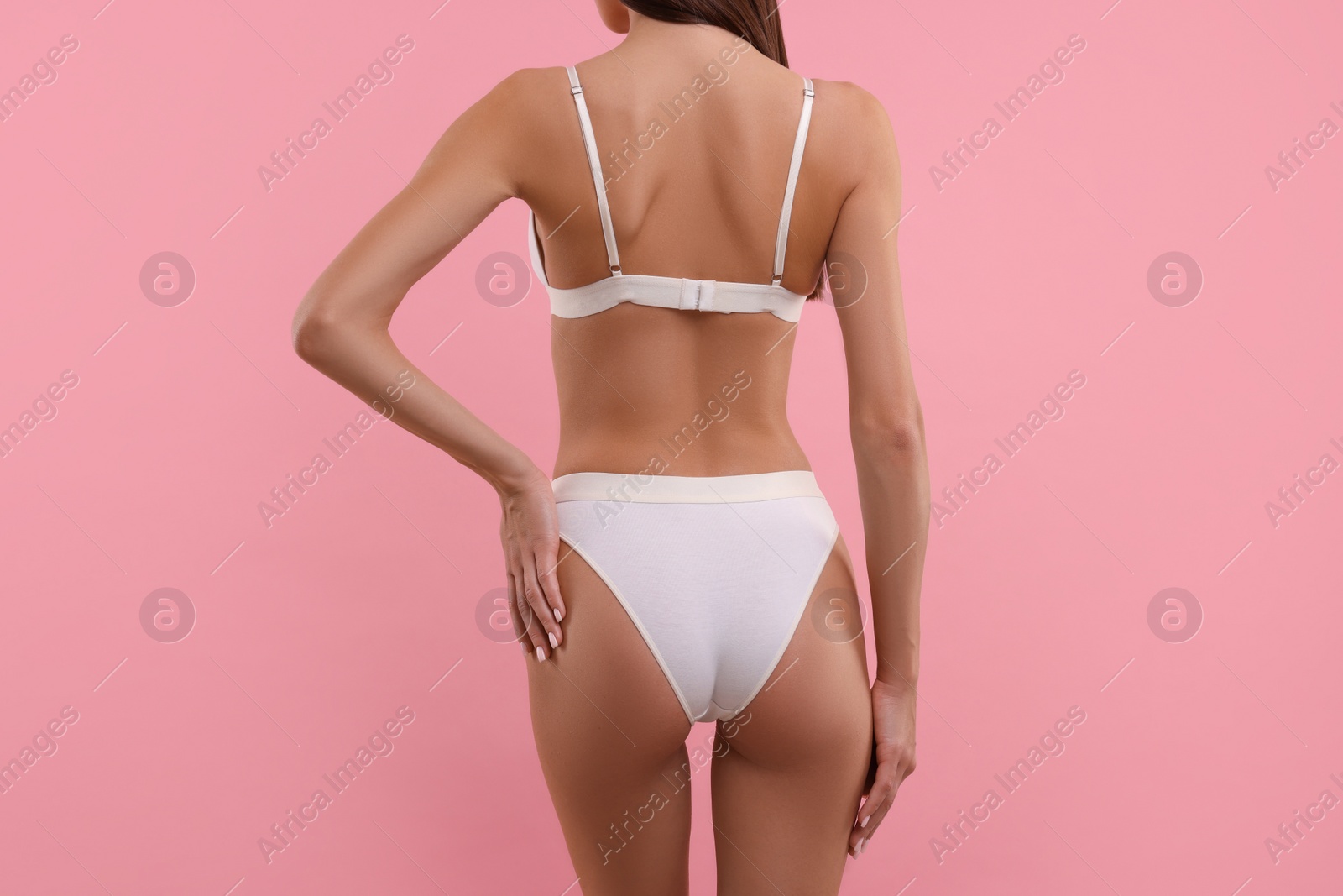 Photo of Young woman in stylish white bikini on pink background, closeup