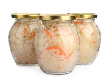 Photo of Glass jars of tasty fermented cabbage with carrot on white background