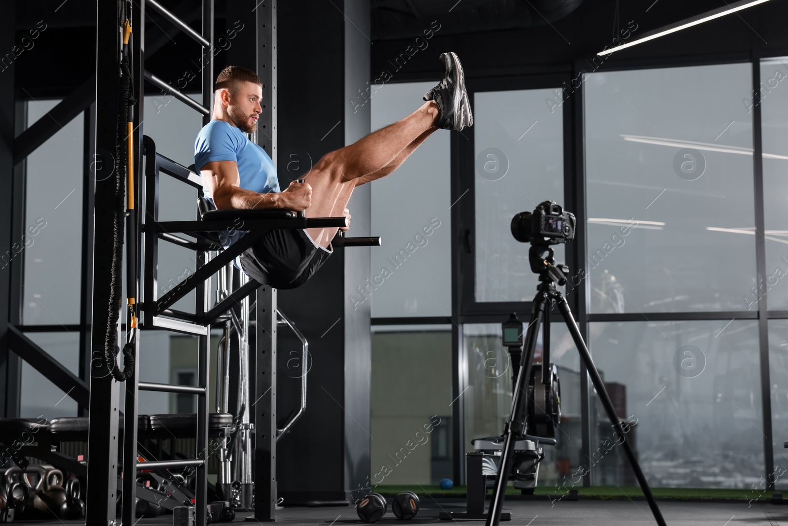 Photo of Man recording workout on camera at gym. Online fitness trainer