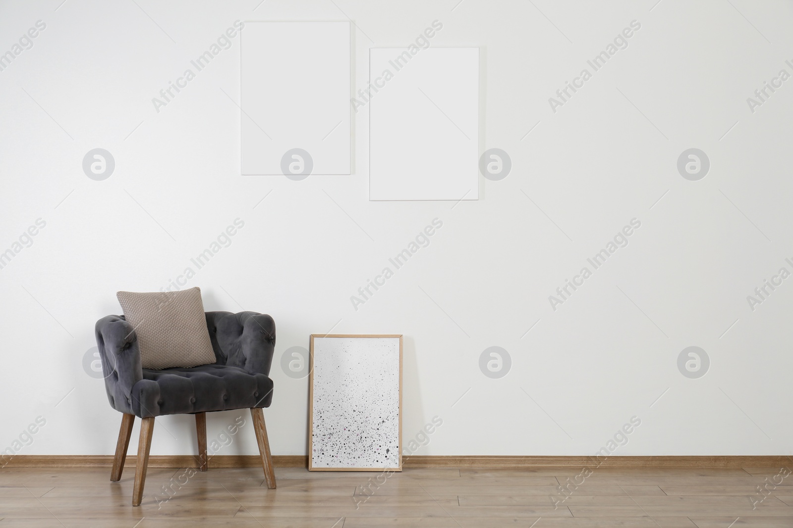 Photo of Room interior with comfortable armchair and posters, space for text