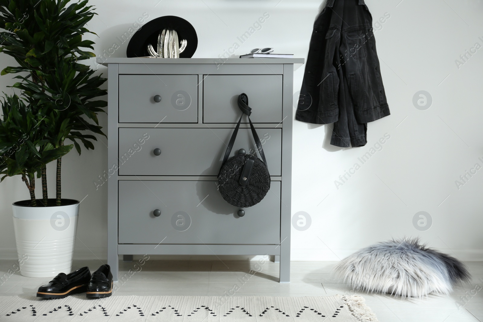 Photo of Grey chest of drawers in stylish room. Interior design