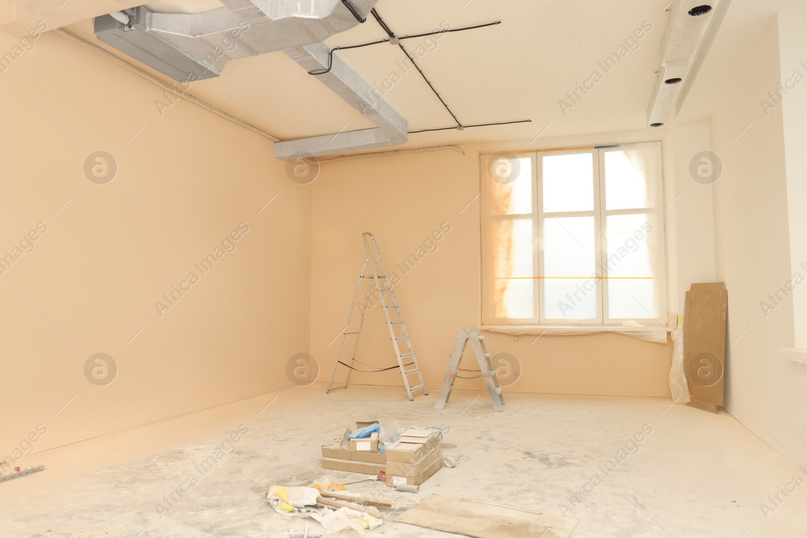 Photo of Room with pale orange walls and windows prepared for renovation