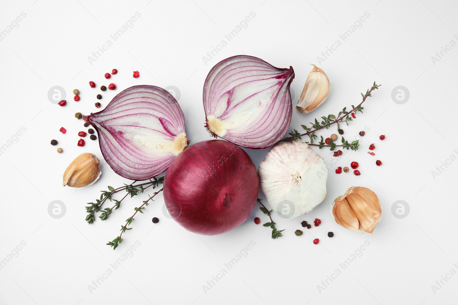 Photo of Fresh red onions, garlic, thyme and spices on white background, flat lay