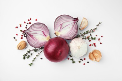 Photo of Fresh red onions, garlic, thyme and spices on white background, flat lay