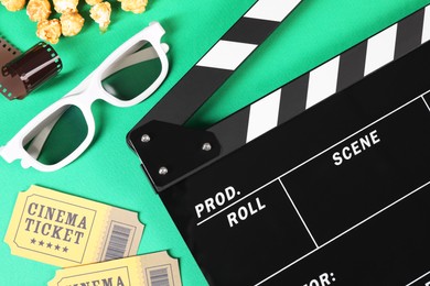 Flat lay composition with clapperboard, movie tickets and 3D glasses on green background