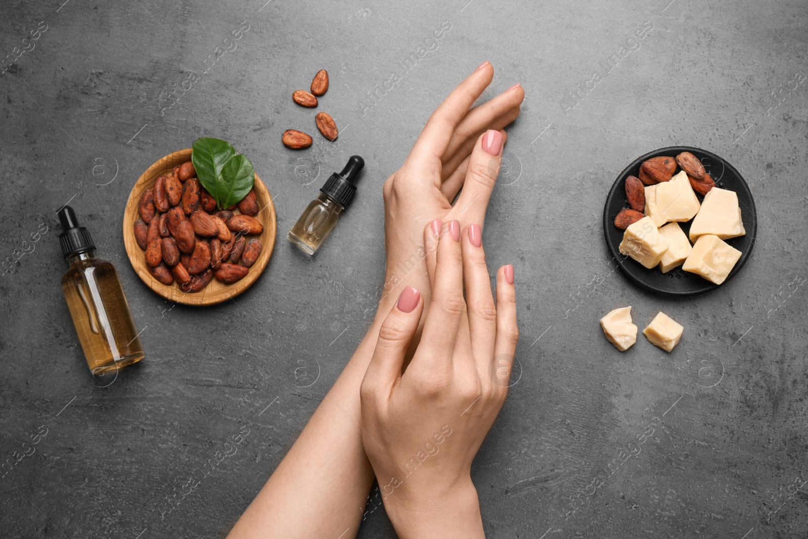 Photo of Woman applying organic cocoa butter at table, top view