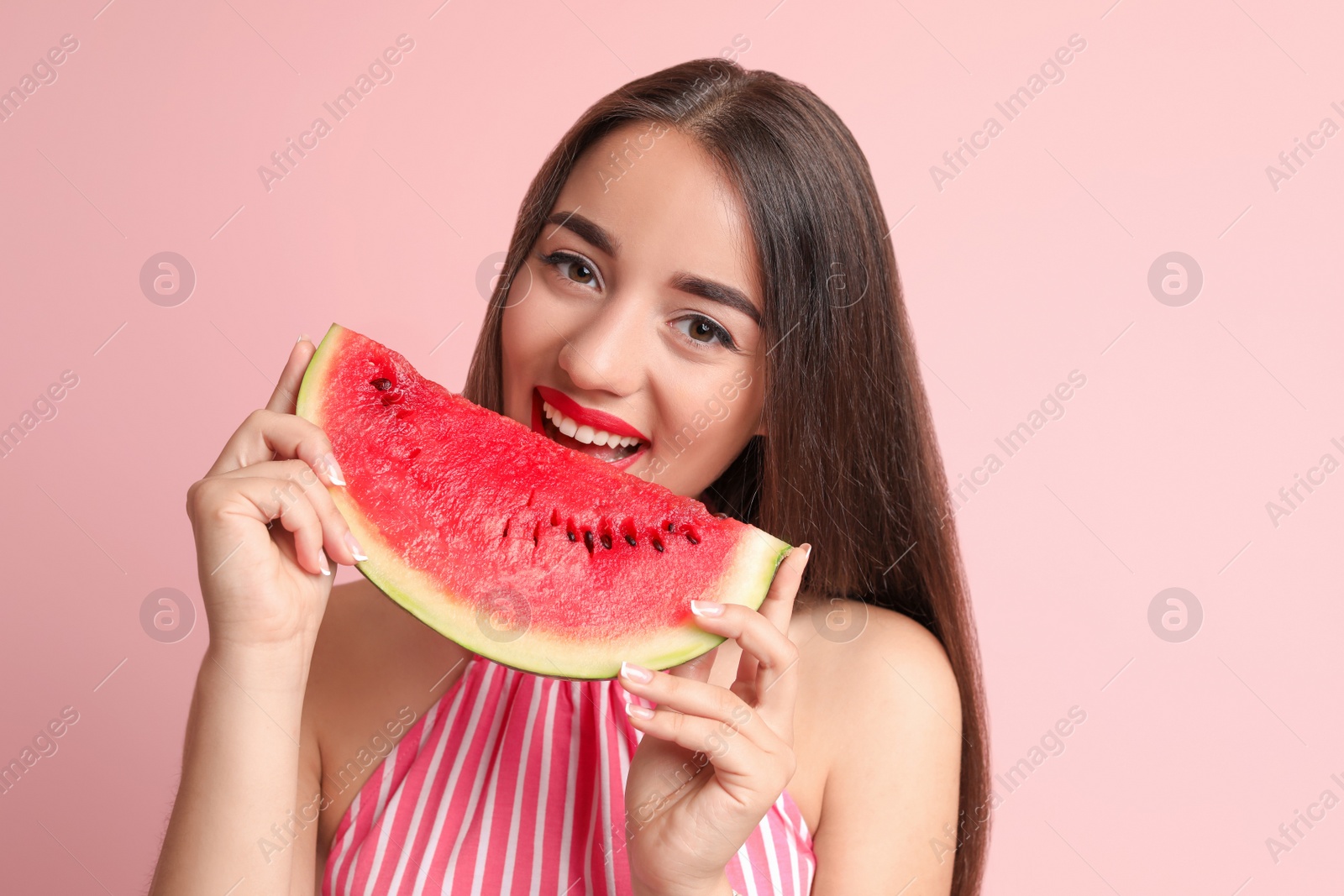 Photo of Beautiful young woman posing with watermelon on color background