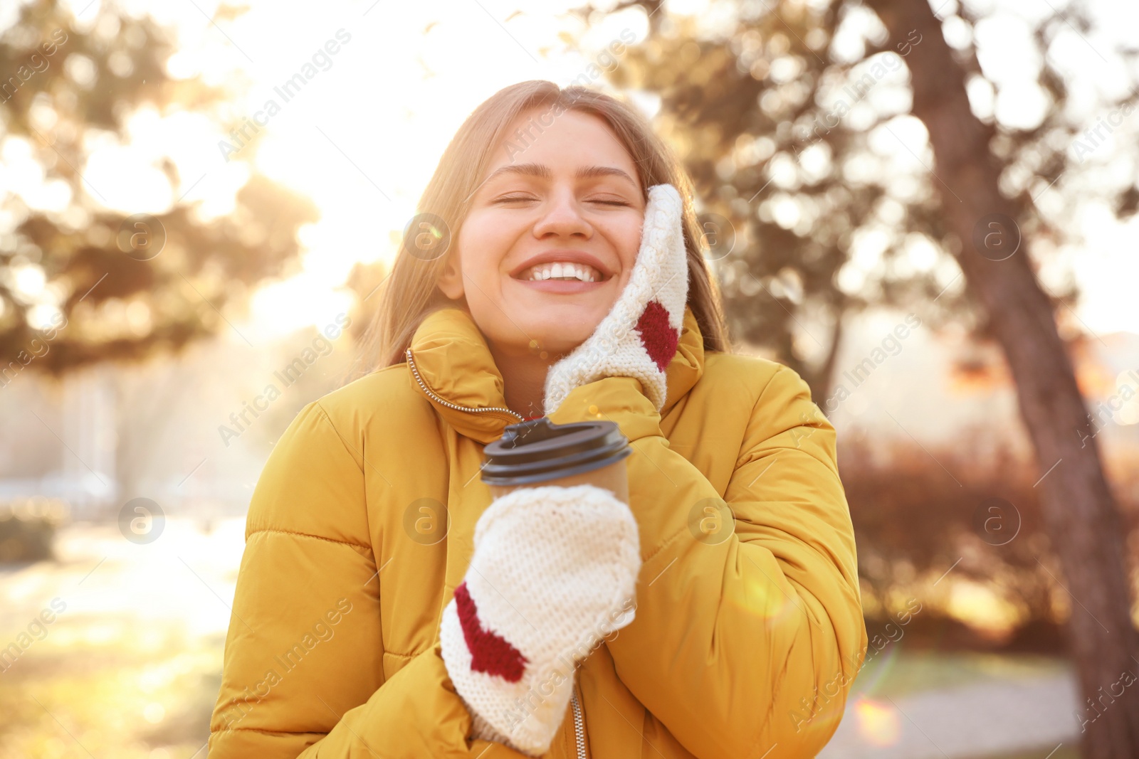 Photo of Young woman with cup of coffee in morning outdoors