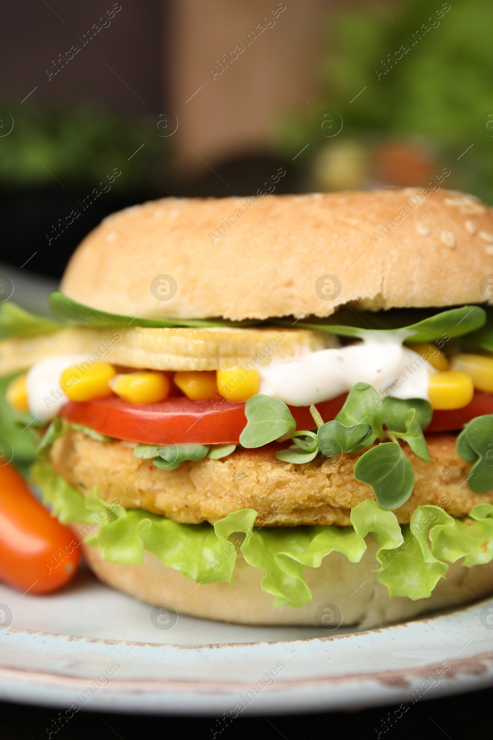 Photo of Tasty vegan burger with vegetables, patty and microgreens on white plate, closeup