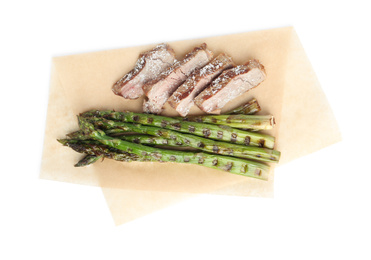 Photo of Tasty meat with grilled asparagus isolated on white, top view