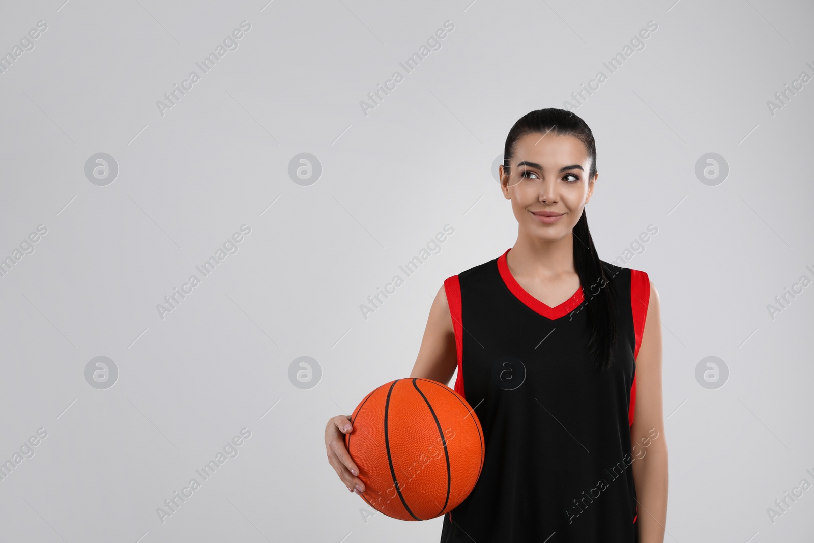 Photo of Basketball player with ball on grey background. Space for text