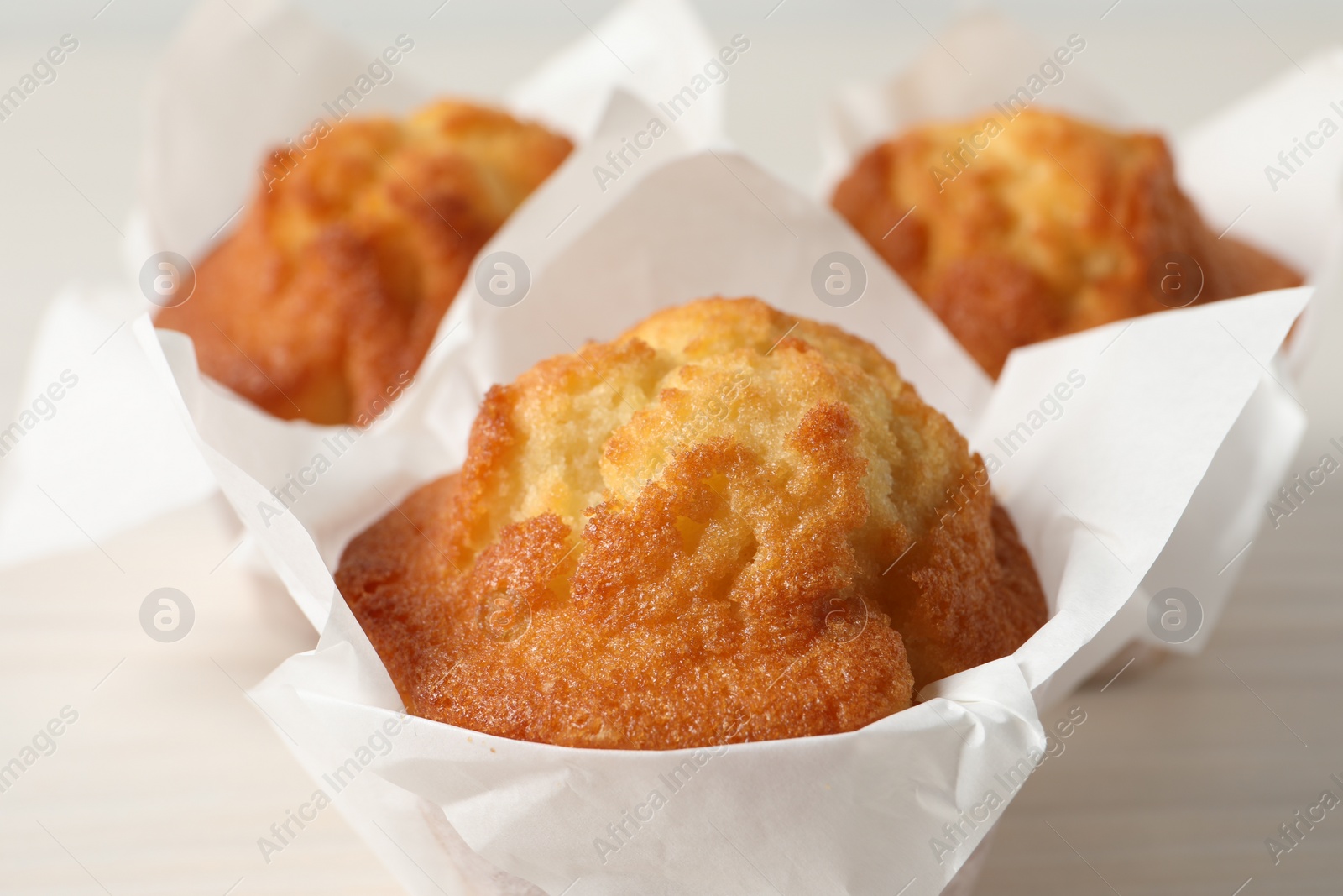 Photo of Tasty muffins on white table, closeup. Fresh pastry