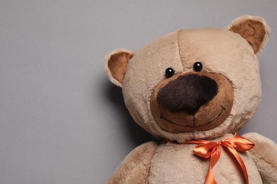 Cute teddy bear on gray background, top view. Space for text