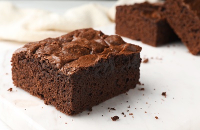 Photo of Pieces of fresh brownie on white table, space for text. Delicious chocolate pie