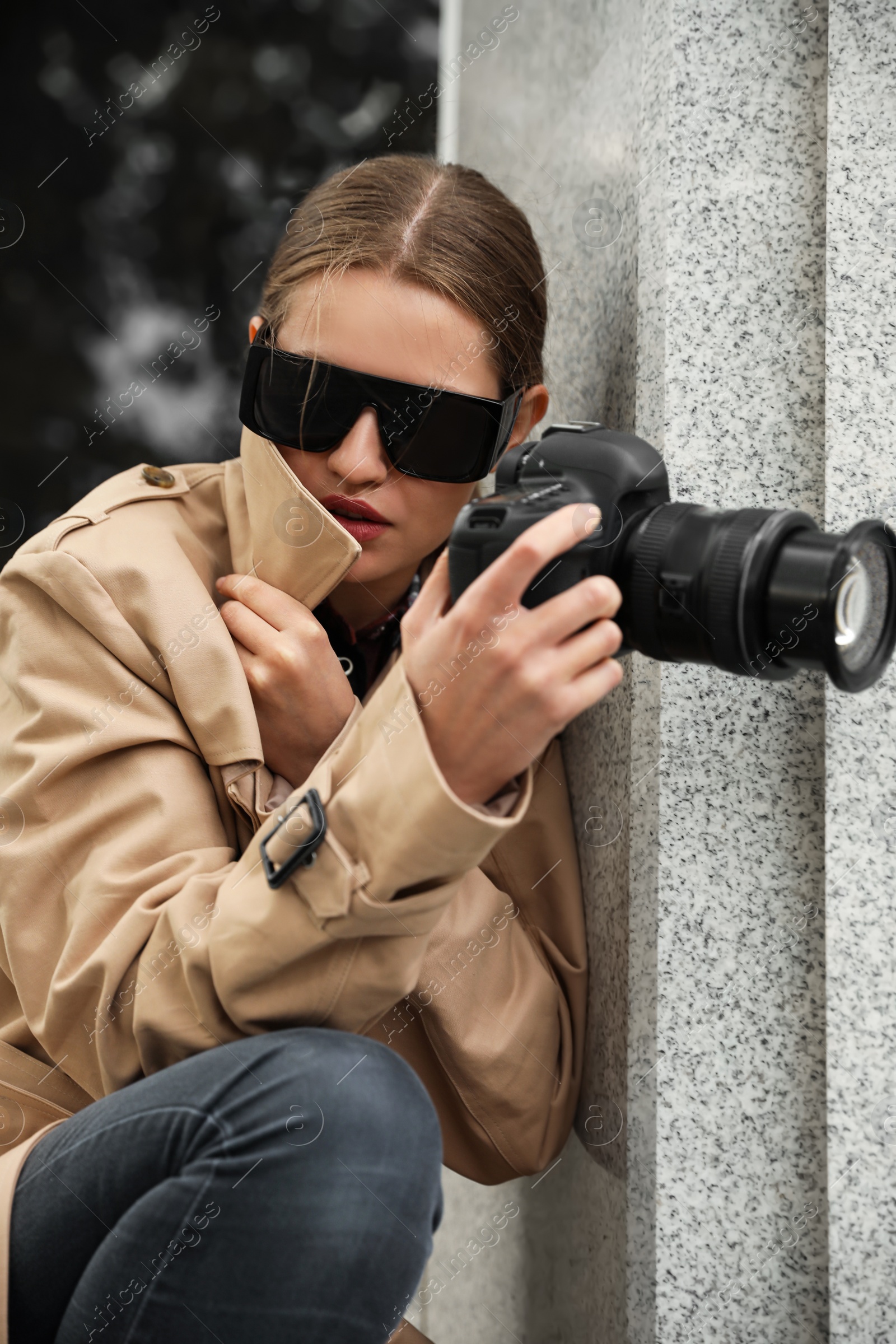 Photo of Private detective with modern camera spying on city street