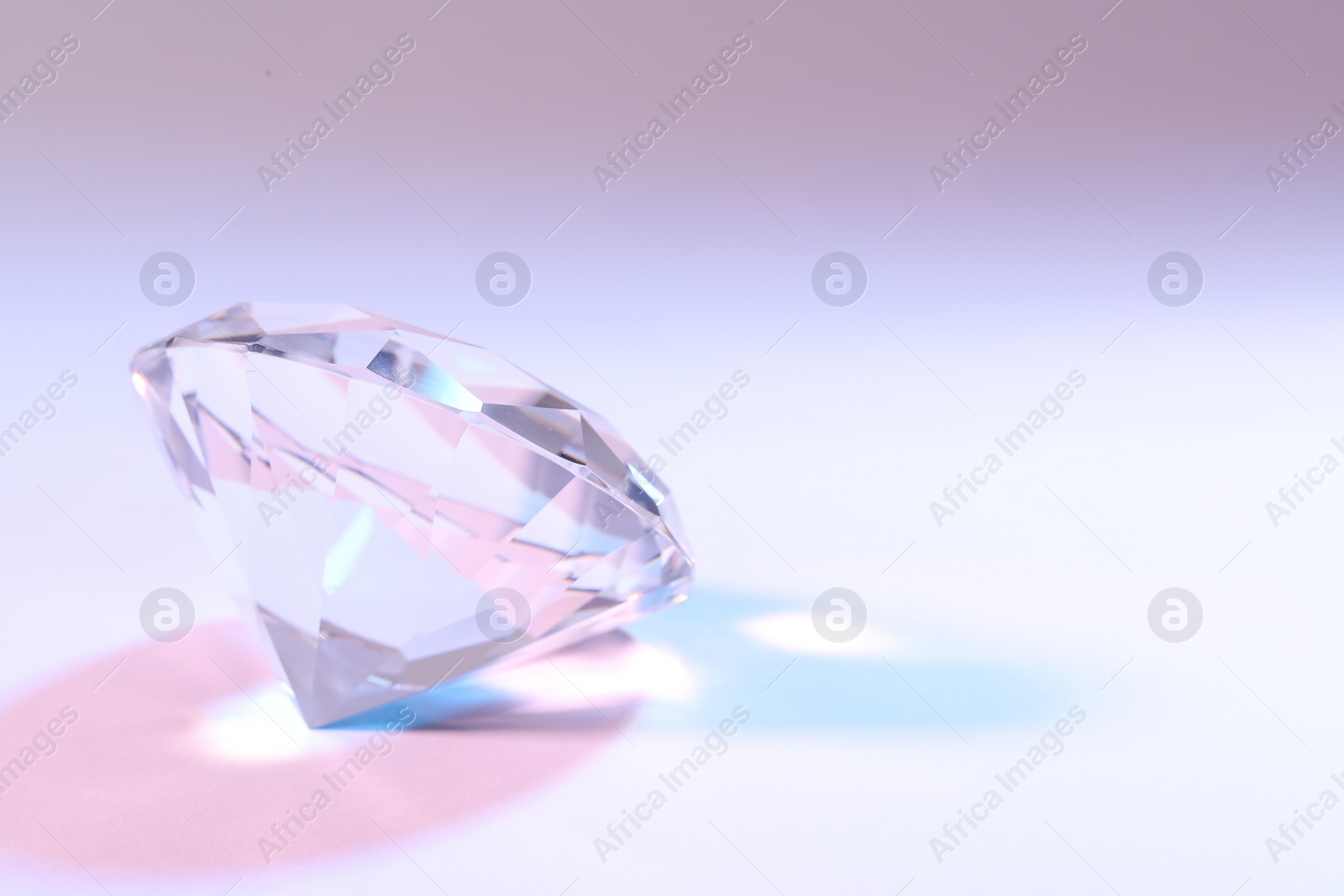 Photo of Beautiful dazzling diamond on color background, closeup. Space for text
