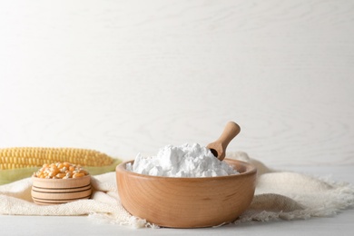 Photo of Bowls with corn starch and kernels on table