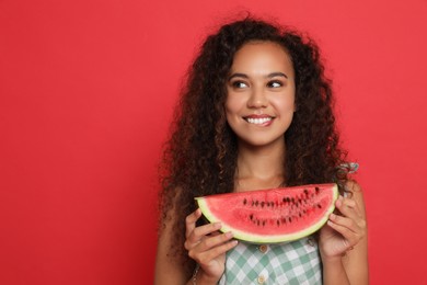 Beautiful young African American woman with slice of watermelon on red background. Space for text