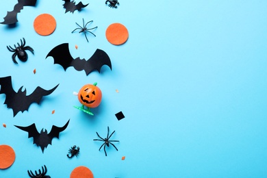 Halloween decor elements on light blue background, flat lay. Space for text