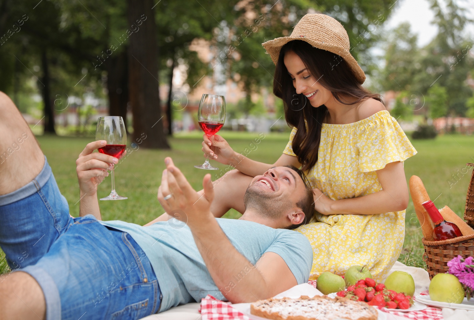 Photo of Happy young couple having picnic in park on summer day