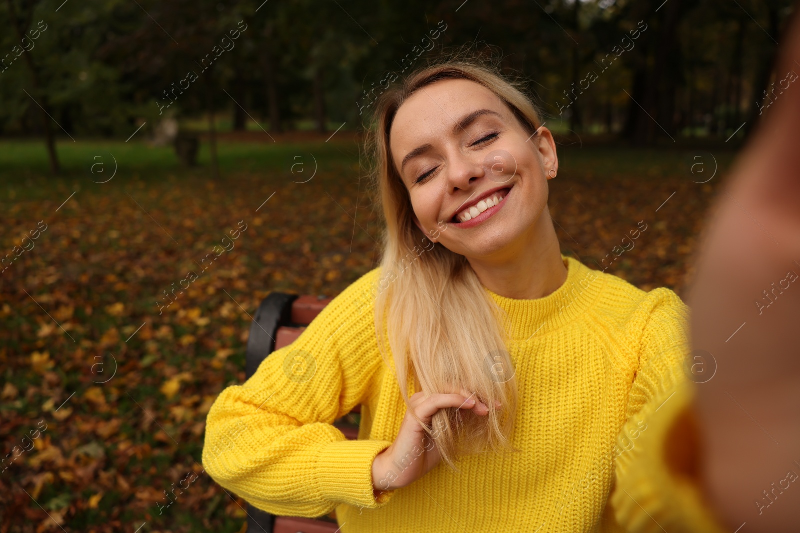 Photo of Portrait of happy woman taking selfie in autumn park