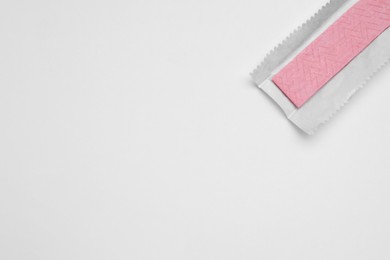 Photo of Unwrapped stick of chewing gum on white background, top view