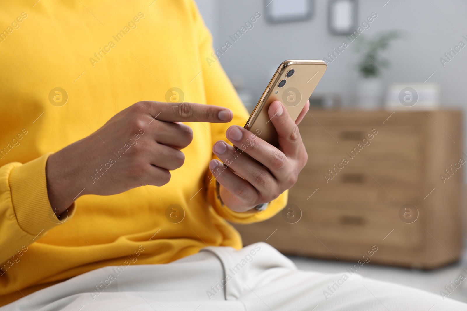 Photo of Man sending message via smartphone indoors, closeup