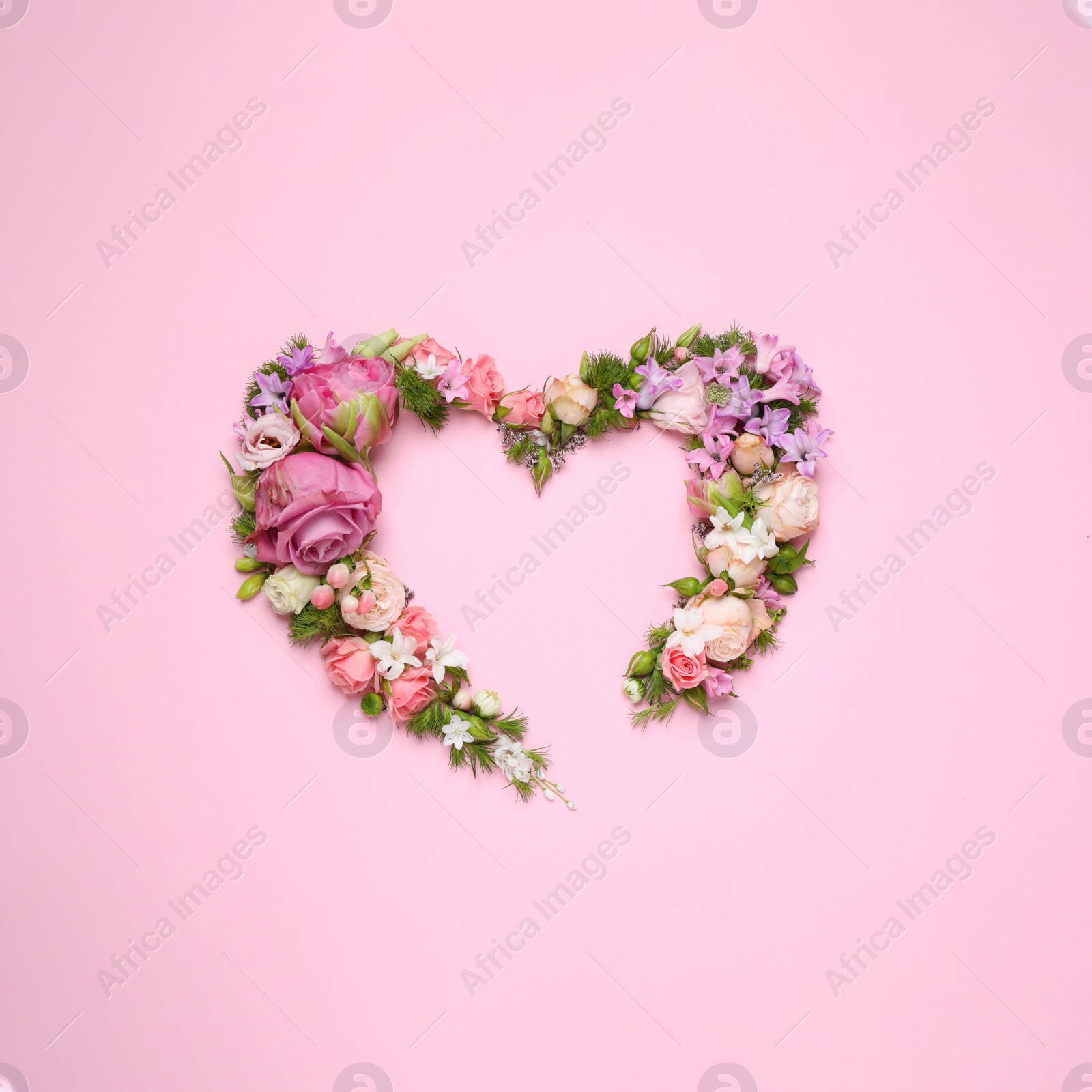 Photo of Beautiful heart made of different flowers on pink background, flat lay. Space for text