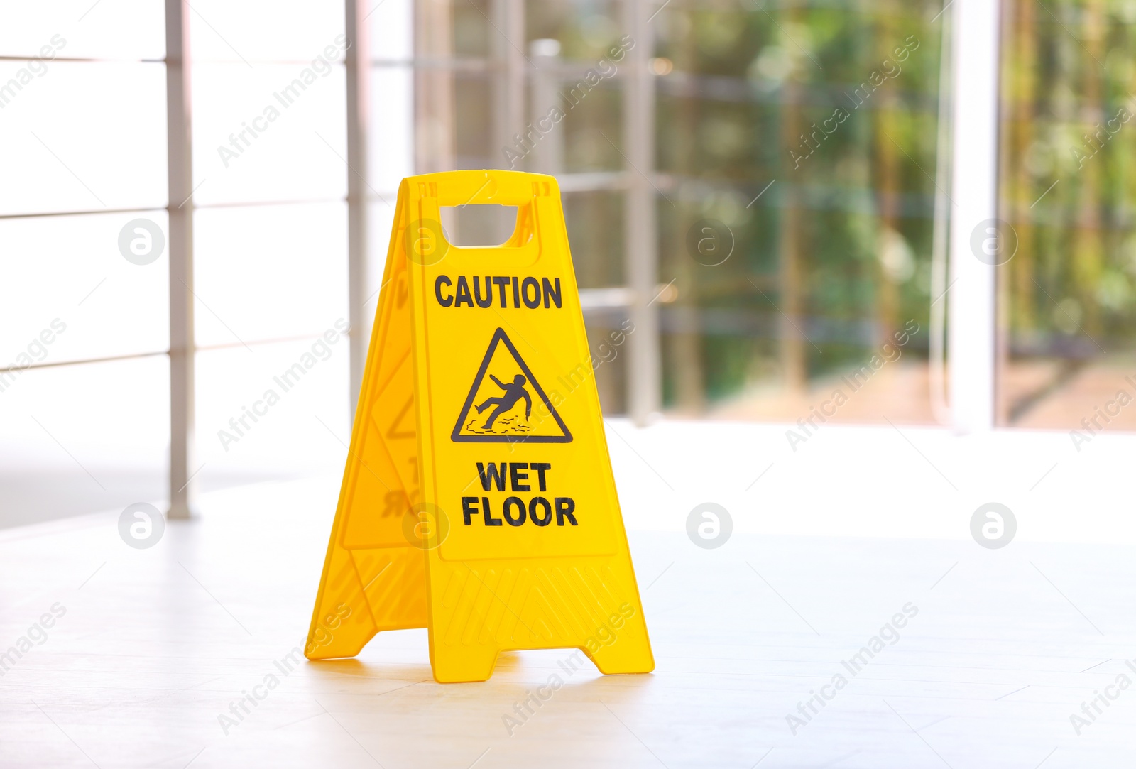 Photo of Safety sign with phrase Caution wet floor, indoors. Cleaning service