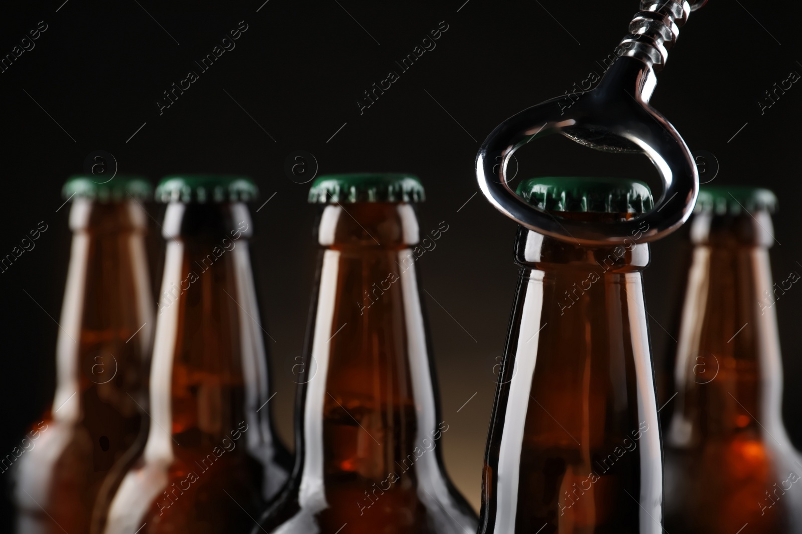 Photo of Opening bottle of beer on dark background, closeup